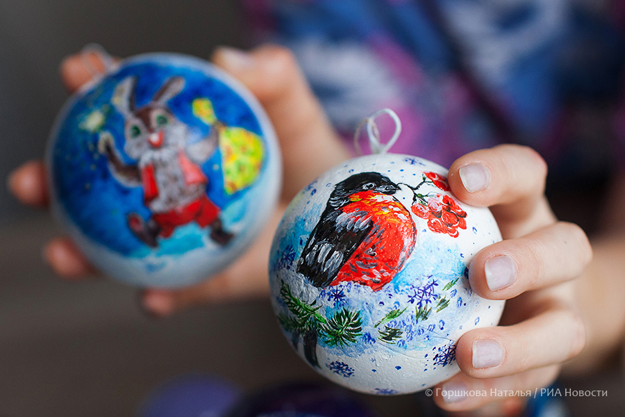 18.11.2020. Мастер Людмила Рогова демонстрирует готовые елочные шары, расписанные вручную, у себя дома в Тюмени. Рисунки выполнены по мотивам работ художника Владимира Зарубина. (Автор фото Наталья Горшкова)